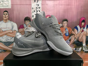 Angled view of the gray Nike basketball sneaker pair showing the padded collar, lace system, Swoosh branding, and textured outsole.