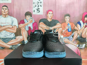 Front view showing the black laces, textured toe boxes, tongue branding, and blue outsole sections.