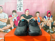 Front view of black Nike basketball shoes with blue tongue details.