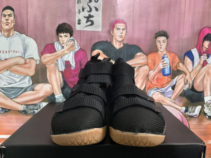 Pair of black Nike basketball sneakers with gum-colored soles shown from the front