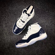Pair of sneakers displayed at an angle, showing the lacing layout, navy overlays, and white uppers.
