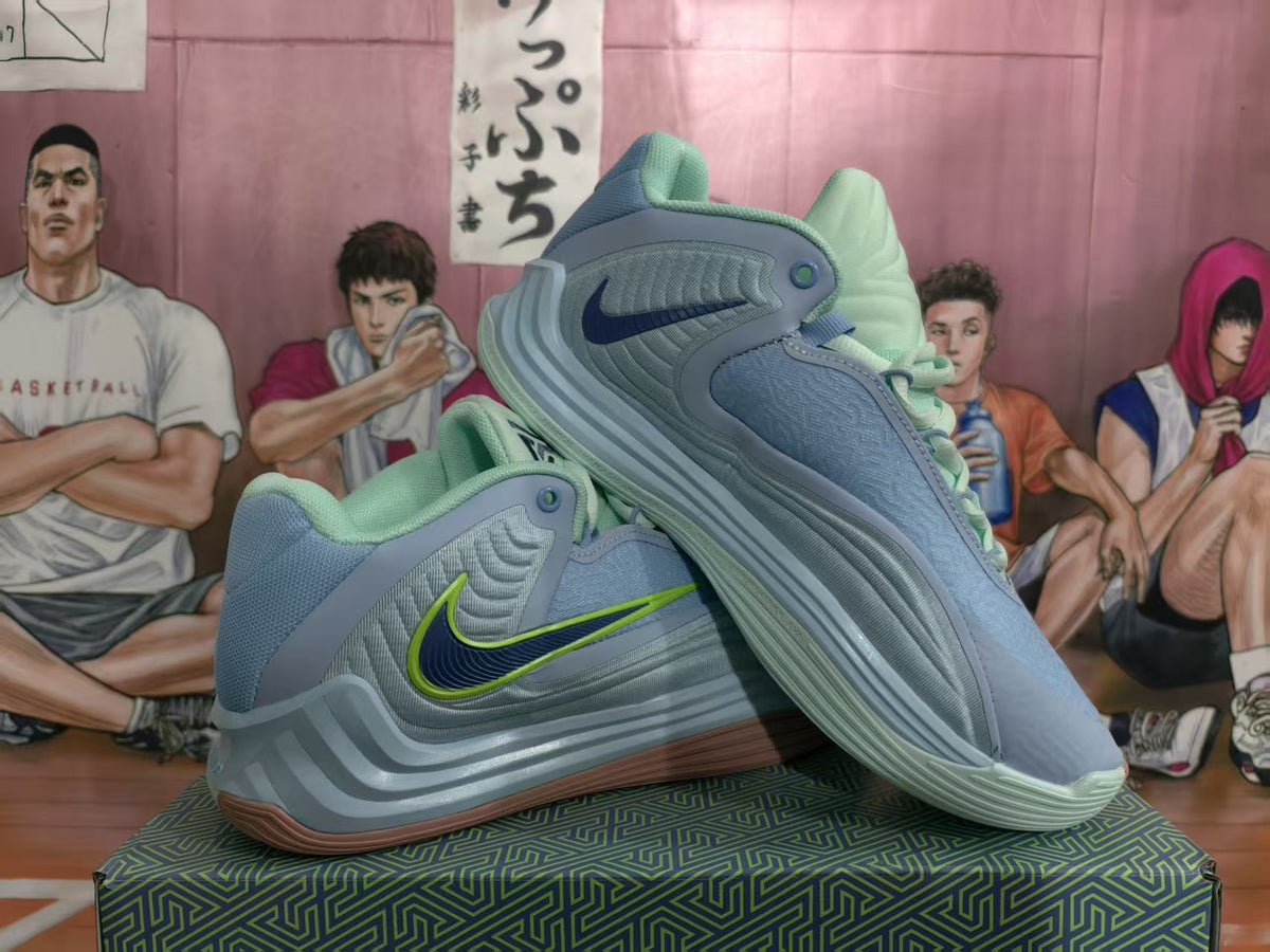 Pair of pale blue and mint green Nike basketball sneakers shown from the side with contrasting Swoosh details.