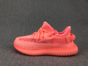 Side profile highlighting the pink knit upper, layered side detailing, pull tab, and translucent sole.