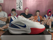 Side view of a white basketball shoe with a blue Swoosh and red forefoot outsole
