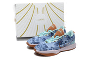 The blue sneaker pair displayed in front of a white-and-gold shoebox.