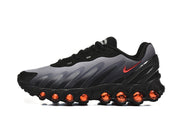 Side profile of a black and grey Nike Air Max DN8 sneaker with red accents.