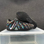 Side view of a multicolor sneaker with one shoe lifted to display the textured black outsole.