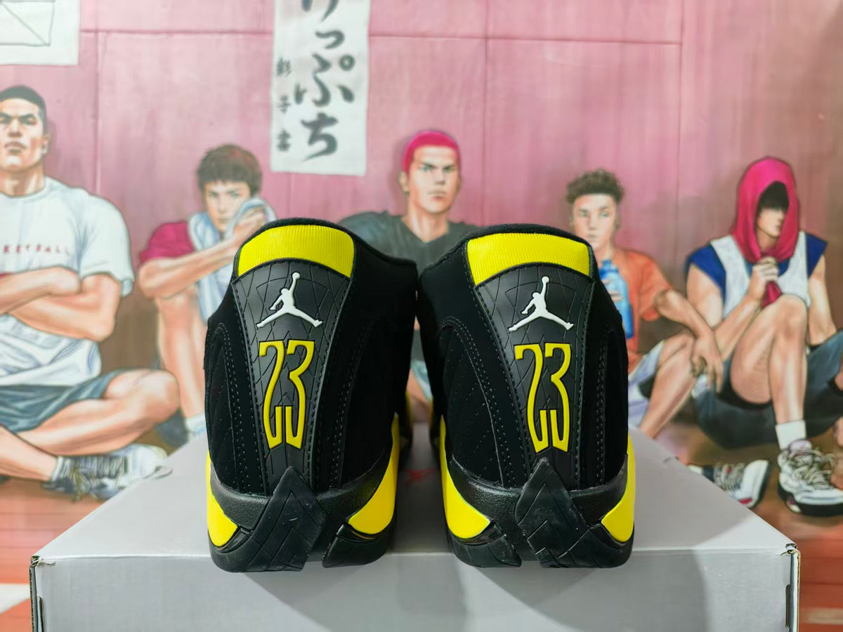 Rear view of black and yellow Jordan basketball sneakers displayed on a shoebox.
