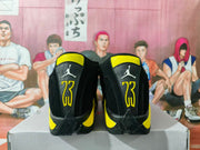 Rear view of black and yellow Jordan basketball sneakers displayed on a shoebox.