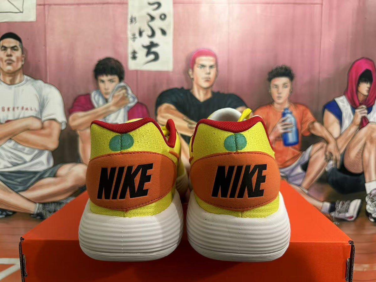Rear view of yellow Nike sneakers with orange heel panels, red trim, green accents, and white textured outsoles.