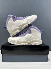 Pair of white and purple high-top sneakers arranged on a black shoebox, showing layered side panels and wavy midsoles.