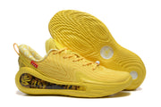 Yellow sneakers shown with one outsole facing upward, displaying the textured tread and graphic outsole inserts.