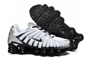 Nike Shox TL sneakers shown from the side with one shoe turned to display the black outsole.