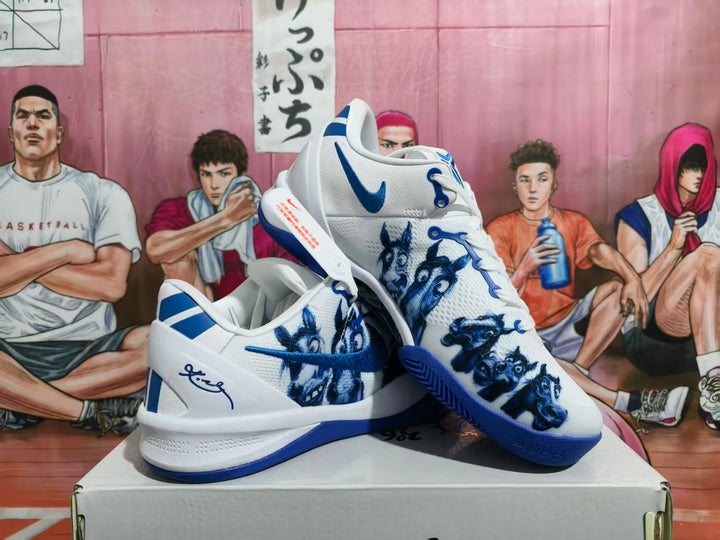 Pair of white and blue Nike basketball shoes displayed on a box, showing the side graphics and blue outsole.