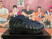 Side profile of a black and navy Nike basketball sneaker with a glossy speckled sculpted side panel and visible swoosh.
