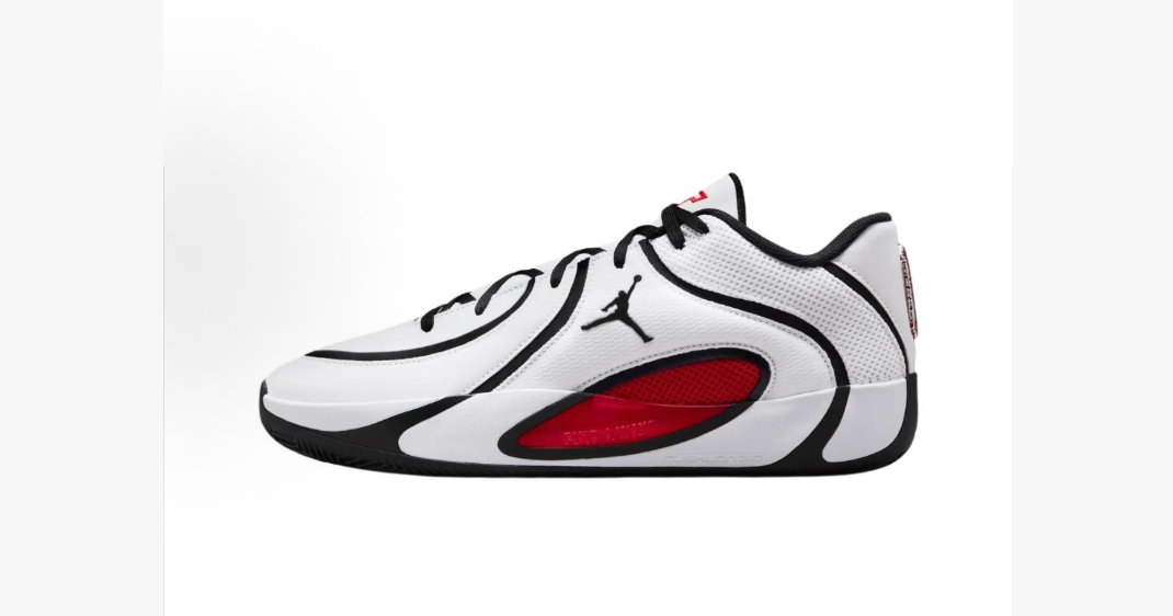 Side view of white Jordan sneakers with black trim, red side accents, and a visible Jumpman logo.