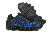 Black and blue Nike Shox sneakers showing the patterned outsole