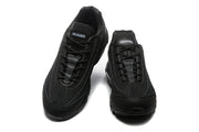 Top view of black Nike sneakers with lace-up closure and A Ma Maniére tongue labels.