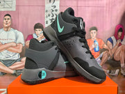 Angled view of gray and black basketball shoes with mint accents and high-top collars