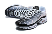 Angled top view of Nike Air Max Plus sneakers highlighting the laces and wavy upper design