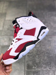 Close side view showing perforated red and white panels, white laces, black trim, and the heel cushioning window.