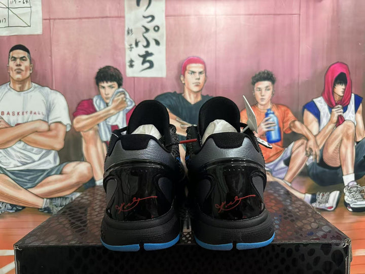 Rear view of black Nike Kobe basketball shoes with red heel signatures and blue outsole accents.