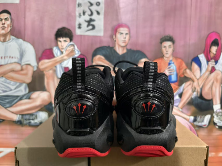 Rear view of black and red Nike basketball sneakers displayed on a shoebox.