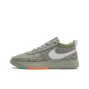 Olive green low-top sneaker with patterned panels, white side swoosh, and orange outsole detail.