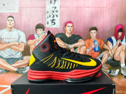 Side view of a black high-top basketball shoe with a yellow Swoosh and red outsole.