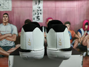 Rear view showing black collars and gold LeBron-style heel marks on white basketball shoes.