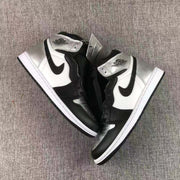 Top-down view of the pair showing the black overlays, white side panels, metallic silver toe areas, and ankle collars.