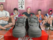Front view of gray and black Nike sneakers showing the laces, padded tongues, and red tongue branding.