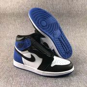 Pair of sneakers displayed with one shoe lifted to show the circular-patterned blue outsole and the black, white, and blue upper.