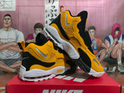 Angled view of yellow and black Nike sneakers showing the side panels and outsole