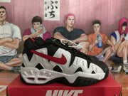 Side view of a black, white, and red Nike sneaker with a wavy side panel and chunky sole.