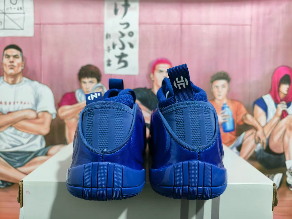 Rear view of royal blue Nike basketball shoes showing pull tabs and textured heel details.