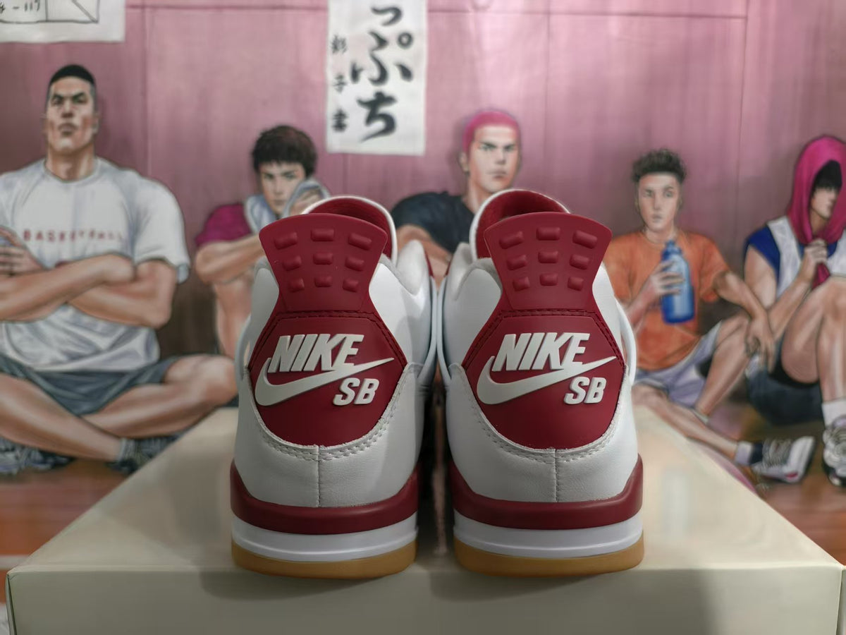 Heel view of white and grey sneakers with red Nike SB heel panels and gum-colored outsoles