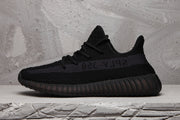 Side profile of a black Yeezy 350 V2 sneaker with a tonal SPLY-350 stripe.