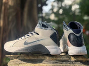 Pair of gray high-top sneakers showing the side Swoosh, black heel panels, and white midsoles.