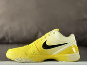 Side profile highlighting the black Swoosh, yellow heel section, and speckled midsole.