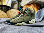 Side profile of the olive high-top sneaker showing its layered construction, black midsole sections, and translucent outsole.
