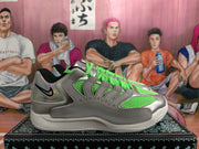 Side view of a Nike sneaker with neon green mesh, silver-gray overlays, an iridescent heel, and a white sole.