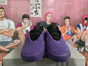 Front view of black and purple basketball sneakers with textured uppers and black interiors.