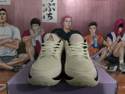 Front view of beige basketball sneakers with cream laces, black accents, and pink tongue logos