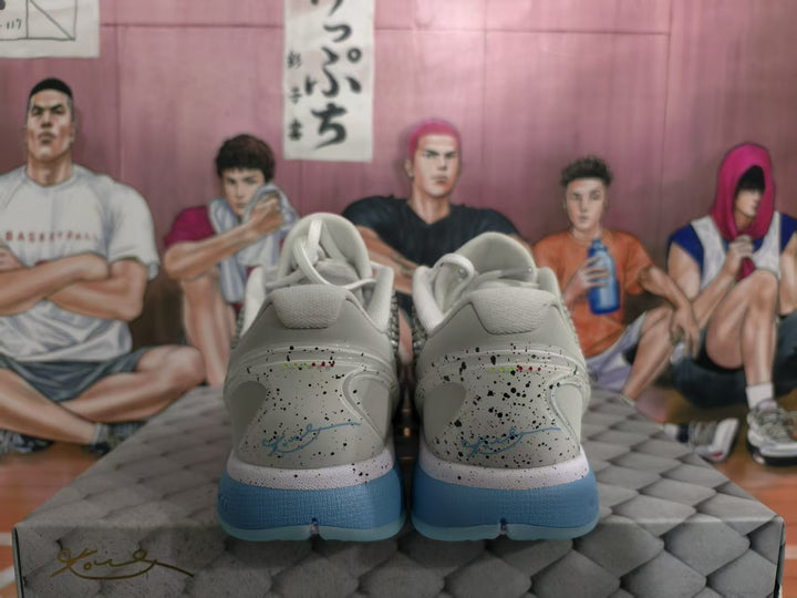 Rear view of white and grey Nike basketball sneakers with speckled heel panels and blue outsoles.