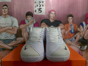 Front view of the white and black Nike Zoom basketball sneakers showing the laces, toe areas, and textured forefoot outsole.