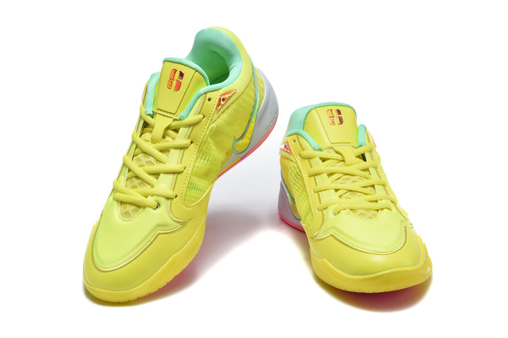 Pair of yellow low-top basketball shoes with mint-green accents and pink outsole details, shown from the front.