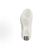 Underside view of a white shoe with circular outsole patterns and dark heel accents