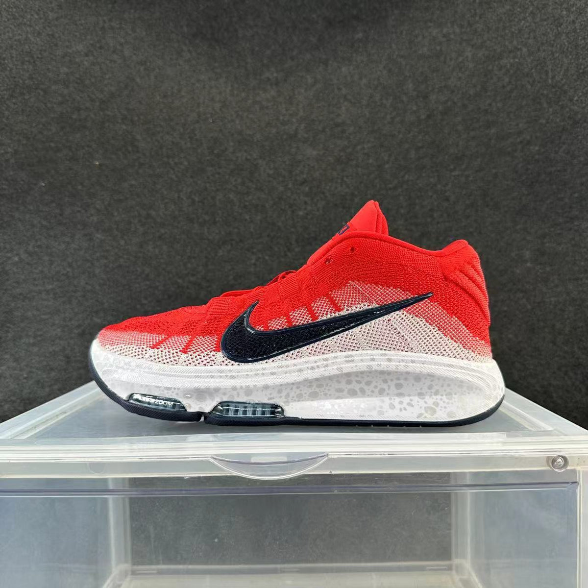 Side view of red, white and black Nike sneakers with a black Swoosh and white midsole