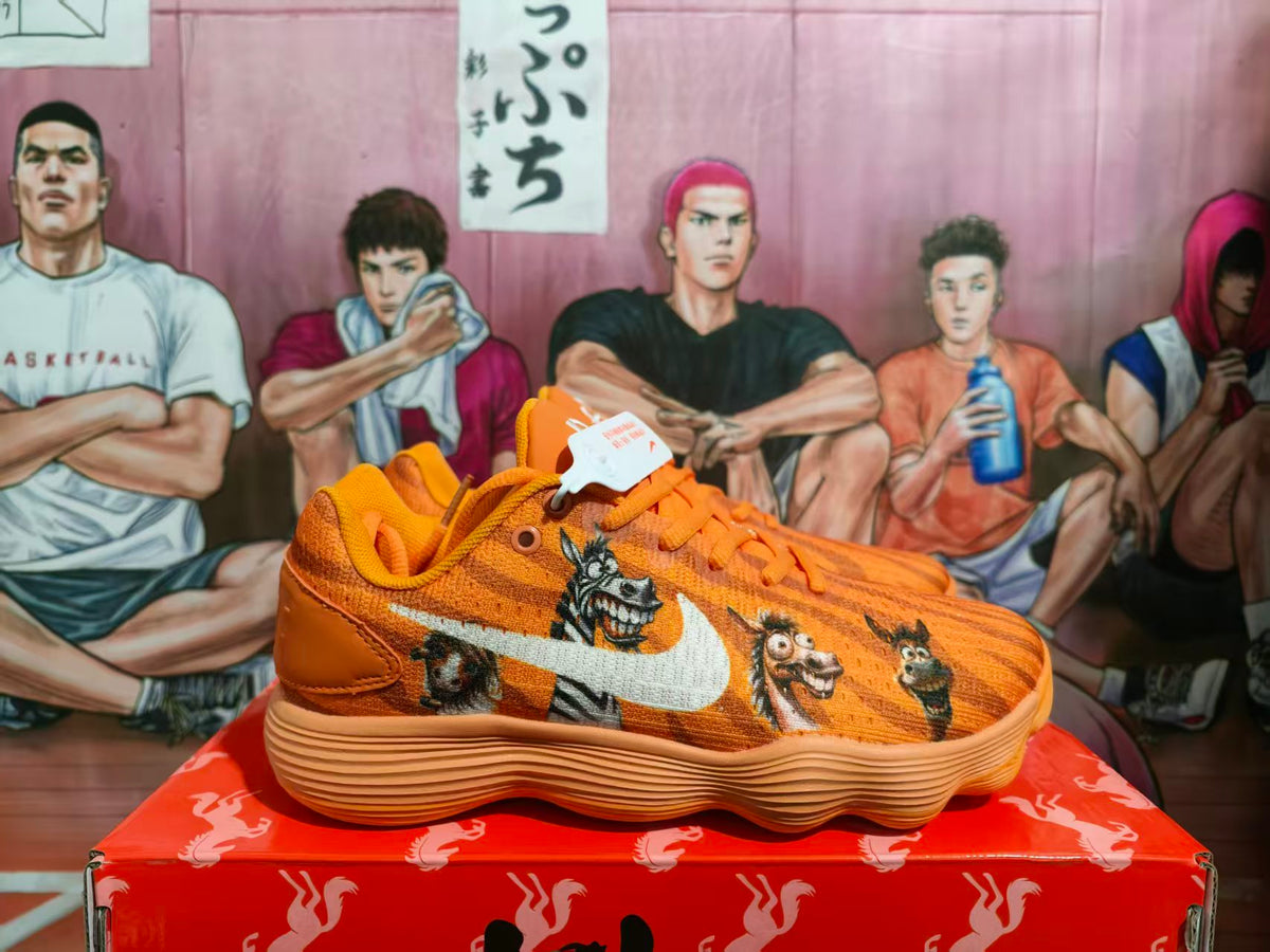 Side view of orange Nike basketball sneakers with animal graphics and a white swoosh.